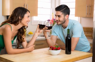 Two lovers stare into each others eyes on a date foreplay with conversation and a romantic mood with wine